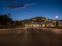 the city skyline is at night from the street level with traffic and pedestrians walking on it