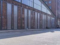 a skate board is sitting in front of a brick building and parked motorcycle on the sidewalk