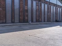 a skate board is sitting in front of a brick building and parked motorcycle on the sidewalk