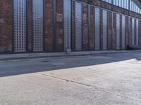 a skate board is sitting in front of a brick building and parked motorcycle on the sidewalk