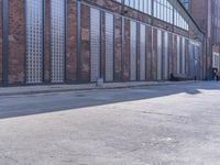 a skate board is sitting in front of a brick building and parked motorcycle on the sidewalk