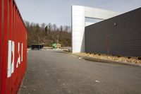 the red containers hold up bags and letters on the outside of a building with a exit sign