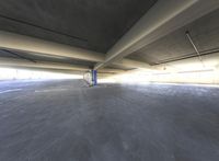 a parking garage has no doors on both sides of the room and one floor has an empty blue space