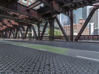 a walkway covered in metal and stone floors next to tall buildings and sky scrapers