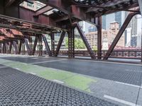 a walkway covered in metal and stone floors next to tall buildings and sky scrapers