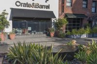 a stone water feature in the foreground outside a cafe and restaurant sign and awning