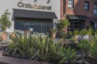 a stone water feature in the foreground outside a cafe and restaurant sign and awning