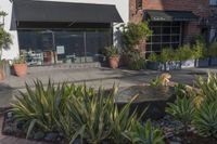 a stone water feature in the foreground outside a cafe and restaurant sign and awning