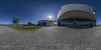 an empty circle with the sun shining and building in the background at the end of it