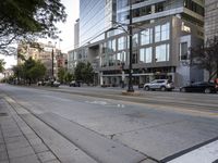 a city street with buildings and cars on the side of it a sidewalk is in front of a traffic light