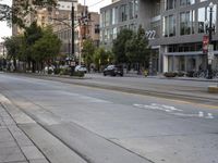 a city street with buildings and cars on the side of it a sidewalk is in front of a traffic light