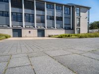 the building is next to an entrance and has a lot of windows and doors in it