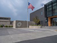 a building with a logo painted on the side near a street that has a sidewalk next to it