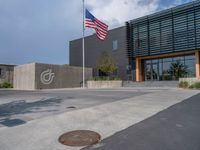 a building with a logo painted on the side near a street that has a sidewalk next to it