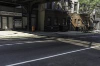 the empty sidewalk has a bus stop at it's side and the shadows come on the pavement