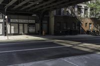 the empty sidewalk has a bus stop at it's side and the shadows come on the pavement