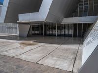 a white building with several steps and large glass panels in the facade is a mosaic that depicts a man