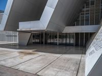 a white building with several steps and large glass panels in the facade is a mosaic that depicts a man