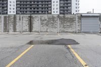 the empty parking lot has only snow on the ground in front of an old brick factory