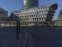 a bus drives in front of some buildings on the street below it is the big, triangular building