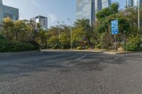 a roadway with lots of greenery in the background near skyscrapers and other buildings