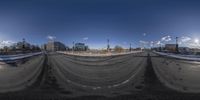 a fish eye lens with buildings in the background from a street level view of the parking lot of a multileved business district