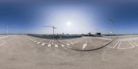 a fish eye view of an empty parking lot with no one on it and lots of buildings in the background