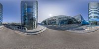 three buildings and their reflection in a large mirror lens lensed photo of a city street