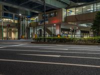 an image of outside of the night time building with the lights turned on and the streets empty