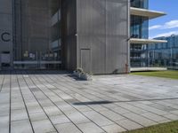 a grey building next to a sidewalk and grass with a black fire hydrant outside