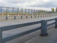 a bunch of benches sitting next to each other under cloudy skies by a street curb