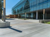 two grey blocks sitting next to a tall building on a sidewalk in front of grass