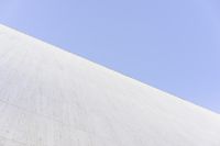 a white building that has been painted with grey paint and has a large area of dirt