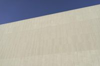 a white building that has been painted with grey paint and has a large area of dirt