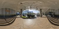 a view of some buildings and benches with no people on them, in a 360 - panoramic photo