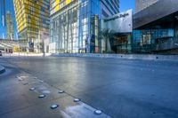 a man walks in a wide open urban area in the sunlight - like setting with modern glass buildings