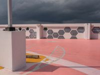 a white building and cement wall with a yellow fire hydrant and a dark sky