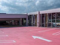 a parking garage that has many cars parked in it with its doors open and there is a pink floor