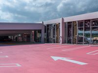 a parking garage that has many cars parked in it with its doors open and there is a pink floor