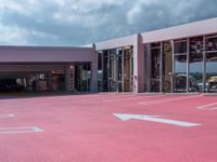 a parking garage that has many cars parked in it with its doors open and there is a pink floor