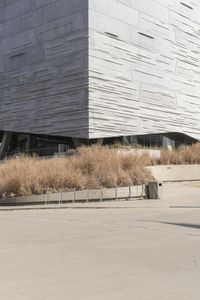 an outdoor area with benches, chairs and a building in the background with tall buildings