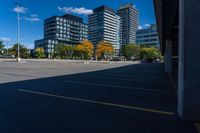 buildings in a city area, as seen from a parking lot in autumn, with a car parked nearby