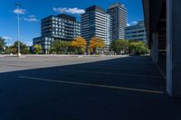 buildings in a city area, as seen from a parking lot in autumn, with a car parked nearby