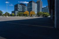 buildings in a city area, as seen from a parking lot in autumn, with a car parked nearby