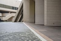 the sidewalk next to a building and man on a phone in front of it,