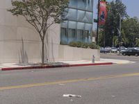 a red fire hydrant sitting on the side of a street next to a building