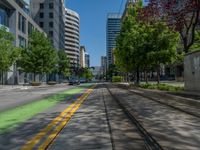 the green paint is painted on a bike path in front of an office building and large, trees