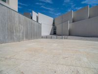 the gray concrete walls of a building have a line of steps on the left side