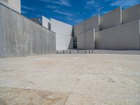 the gray concrete walls of a building have a line of steps on the left side