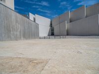 the gray concrete walls of a building have a line of steps on the left side